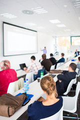 People in a conference room listening to a speech