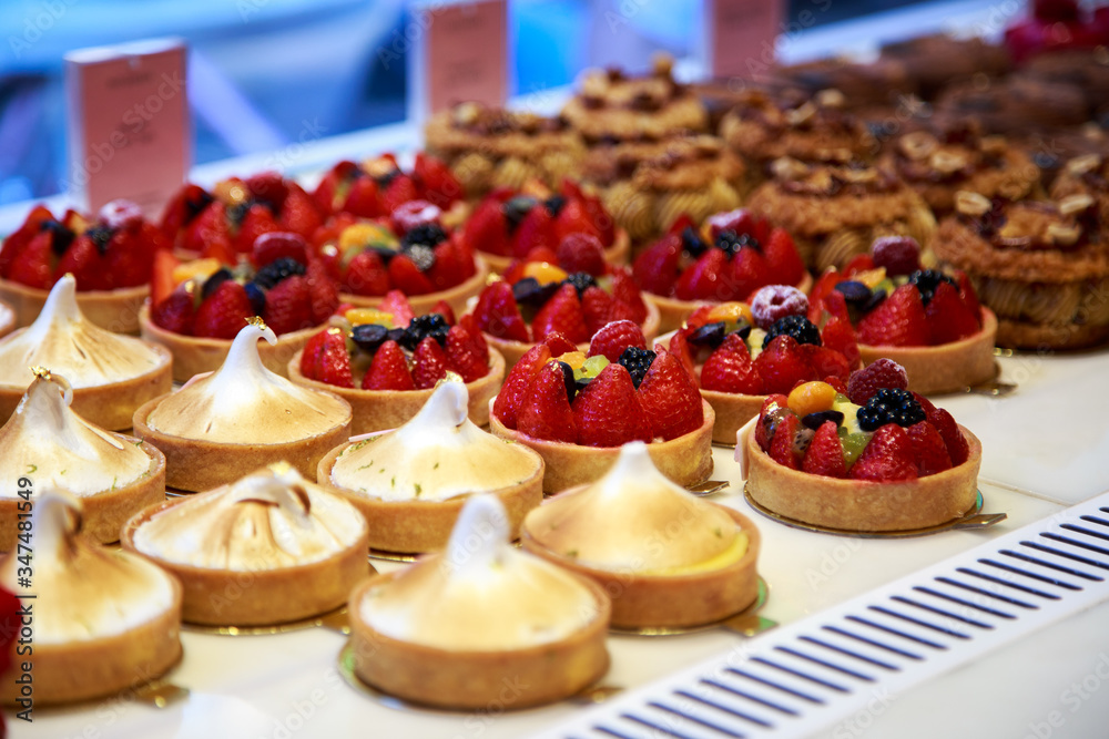 a selection of induvidual cakes in the window of a bakery