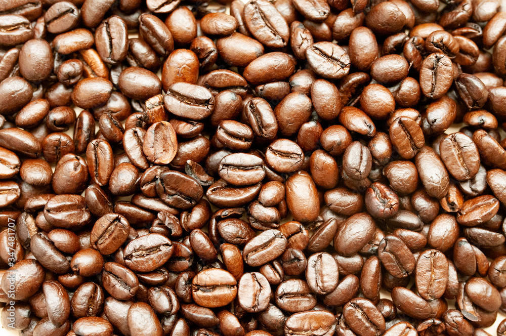Fototapeta premium Coffee beans Coffee scattered on the table, roasted top view, natural sunlight falling on coffee, close up, background.