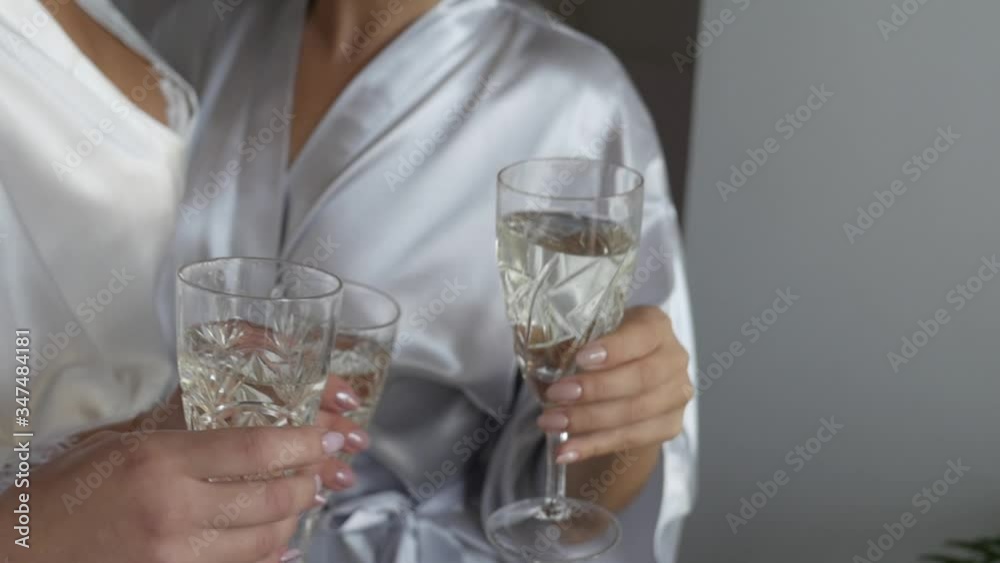 three girls in bathrobes clink glasses three girls in bathrobes clink glasses