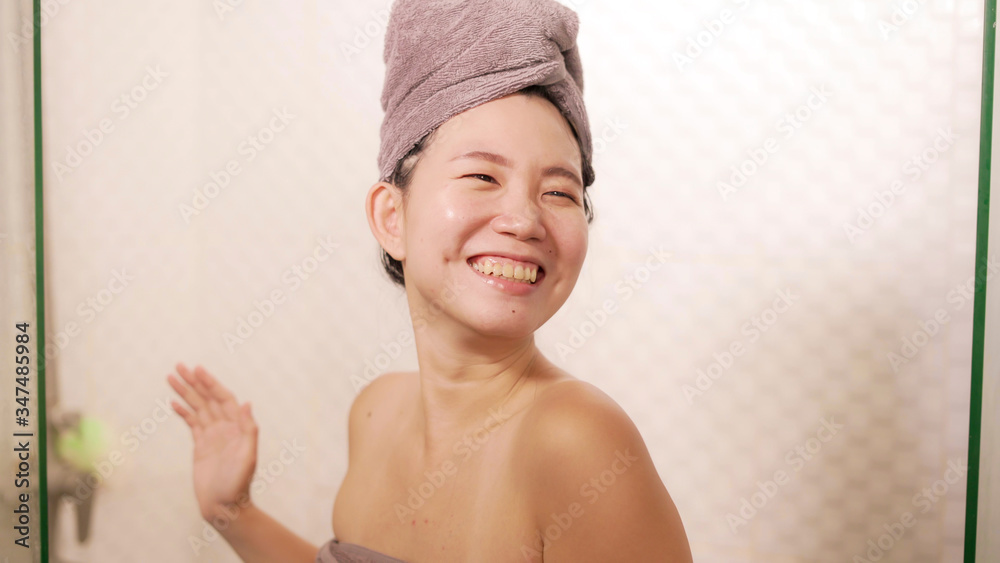 young beautiful and happy Asian Chinese woman with head wrapped in towel smiling fresh and cheerful after taking shower enjoying morning routine and hygiene young beautiful and happy Asian Chinese woman with head wrapped in towel smiling fresh and cheerful after taking shower enjoying morning routine and hygiene