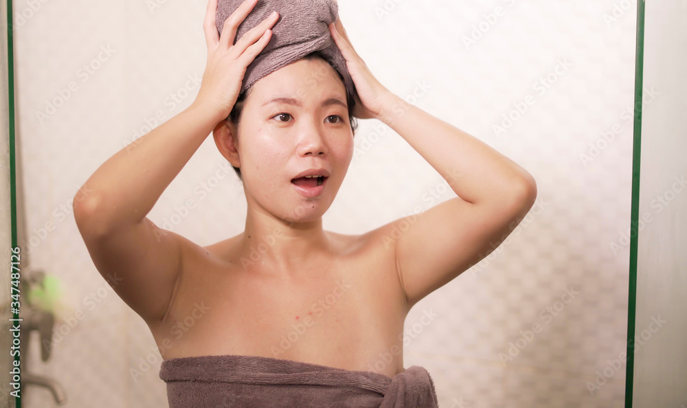 Obraz premium young beautiful and happy Asian Korean woman with head wrapped in towel smiling fresh and cheerful after taking shower enjoying morning routine and hygiene