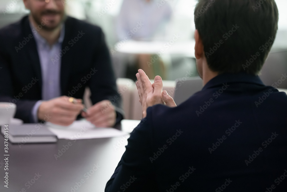 Applicant pass job interview answer questions interact with HR manager feels confident looks very convincing close up back view. Ceo and investor formal meeting communication seated at table concept