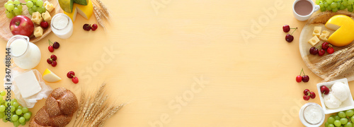 Top view photo of dairy products over pastel yellow background. Symbols of jewish holiday - Shavuot