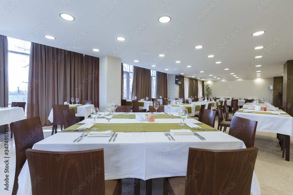 Tables and chairs in large restaurant hall. Empty room