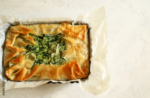 Traditional greek cuisine. Homemade Spanakopita, phyllo pastry pie with spinach and feta cheese. Top view, copy space.
