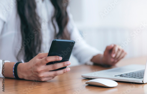 Cropped shot of woman hand using smartphone.