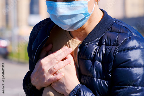 Foto A masked woman in the street felt a twinge of pain in her chest