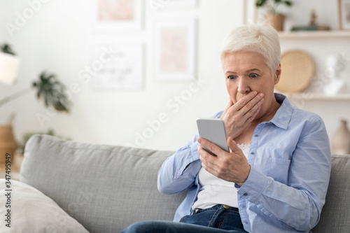 Coronavirus News. Shocked Senior Woman Reading Information On Smartphone At Home