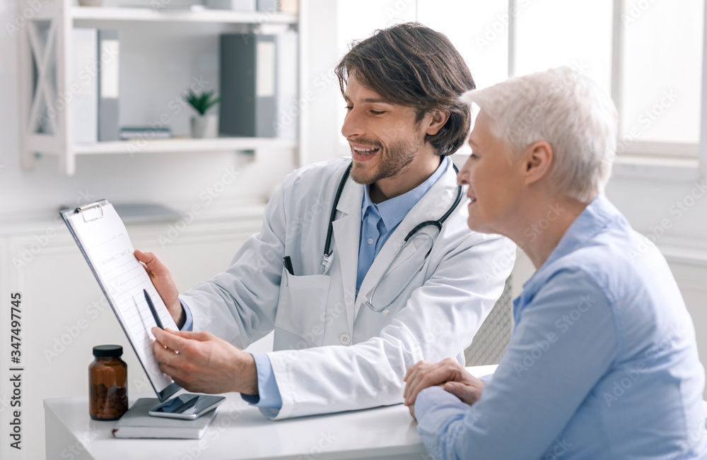 Happy doctor showing positive test results to senior patient Happy doctor showing positive test results to senior patient