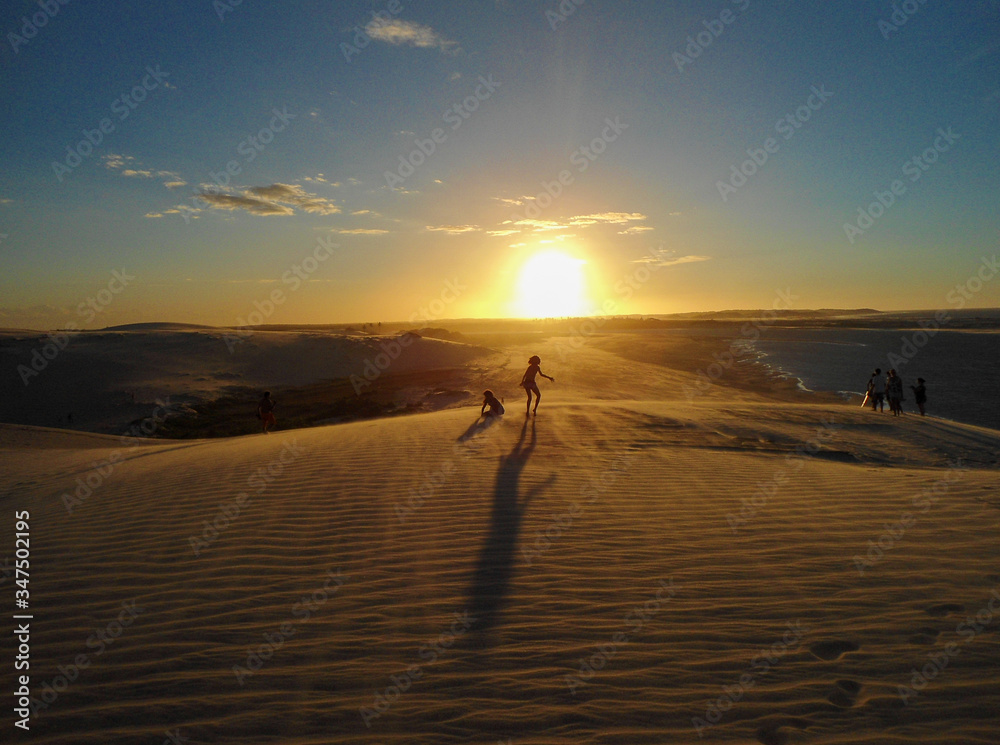Amazing sunset in Jericoacoara beach in Ceara, Brazil, with three people silhouette. Famosu place