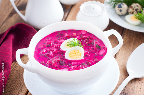 Traditional cold summer beetroot soup with vegetables in a white bowl, selective focus