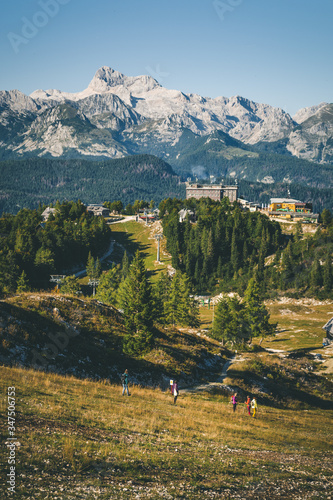 Mountain landscape with people and buildings in foreground and mountains in the background