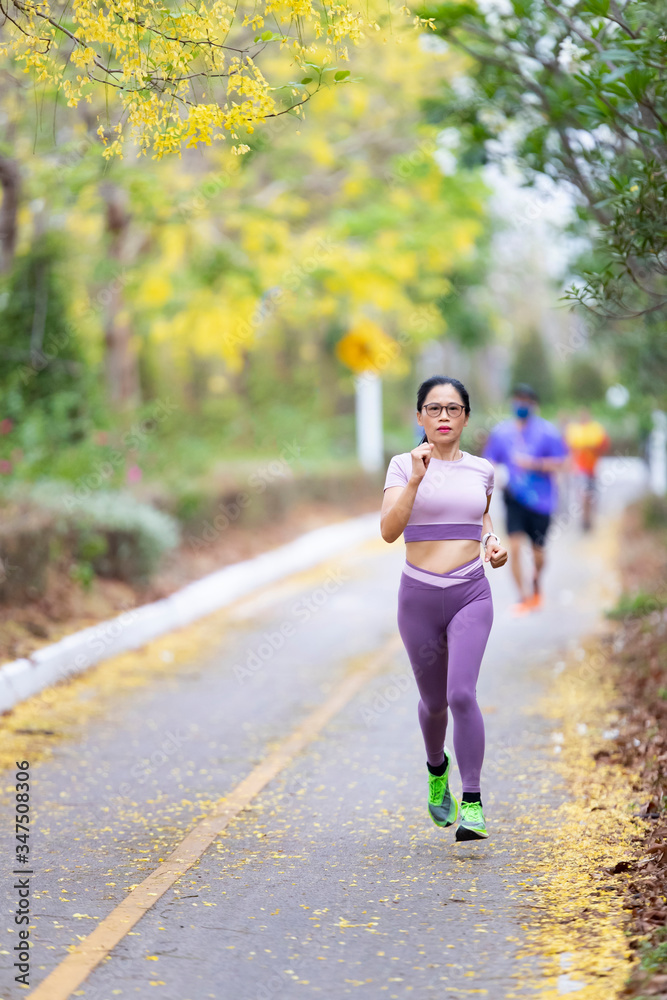 Woman asia running in park. Fitness sporty woman jogger running at outdoors Woman asia running in park. Fitness sporty woman jogger running at outdoors