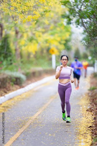 Woman asia running in park. Fitness sporty woman jogger running at outdoors