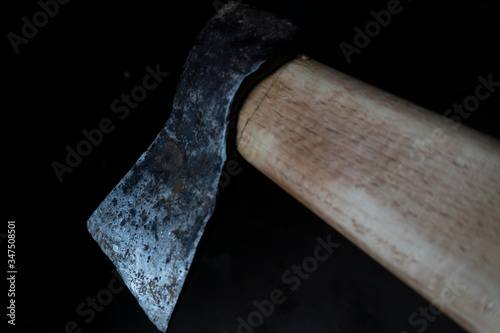 old working ax in hands with notches on a dark background