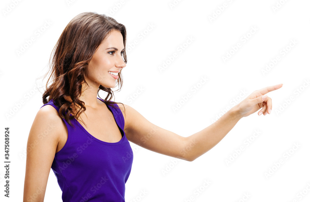 Happy smiling beautiful young woman in violet casual smart clothing, showing copy space, visual imaginary or something, or pressing virual button isolated over white background Happy smiling beautiful young woman in violet casual smart clothing, showing copy space, visual imaginary or something, or pressing virual button isolated over white background
