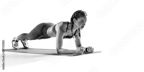 Fototapeta Naklejka Na Ścianę i Meble -  Sport. Young athletic woman doing plank. Muscular and strong girl exercising. Fitness exercising.