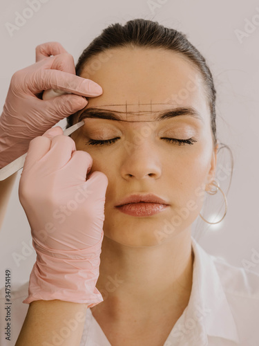 Mikrobleyding eyebrows workflow in a beauty salon. Very beautiful model