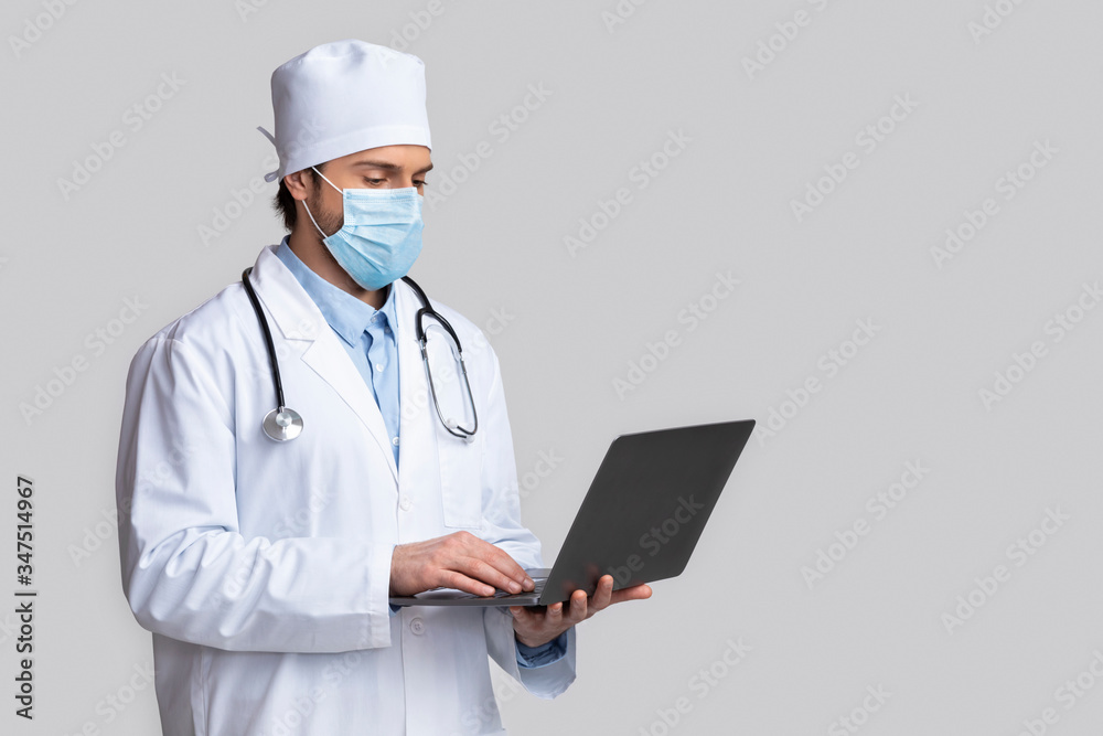 Doctor in protective mask consulting patients on laptop Doctor in protective mask consulting patients on laptop