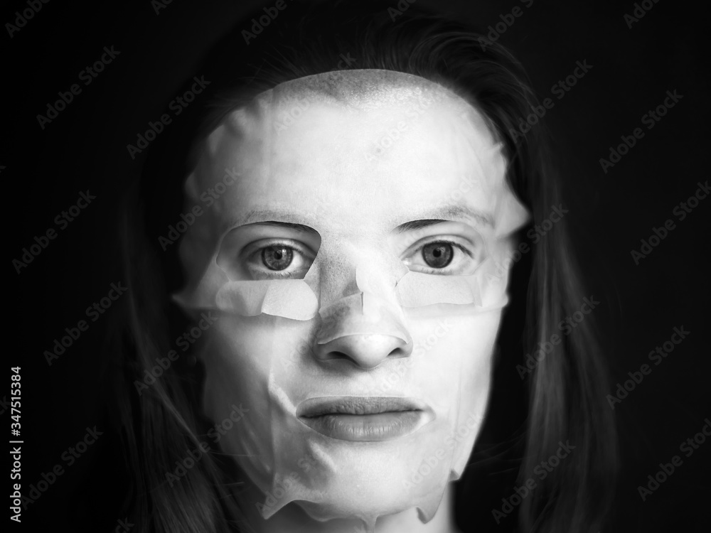 Portrait of a young pretty brown-haired woman with a moisturizing tissue mask