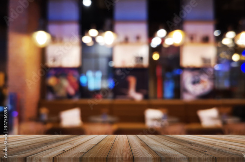 wooden table with abstract blurred background resturant lights used for display montage products mock up design. © thithawat