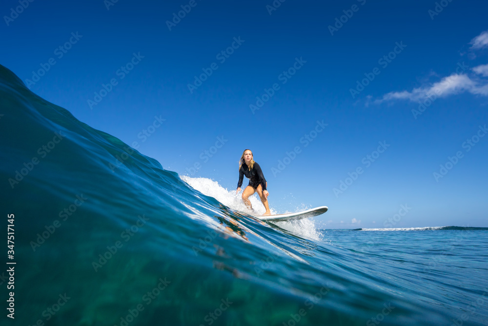 young beautiful blonde girl surf on the big waves in the open ocean. Mauritius Island
