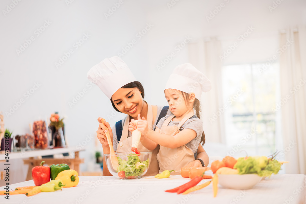 Mother and daughter cooking at home with happiness. Family concept Mother and daughter cooking at home with happiness. Family concept