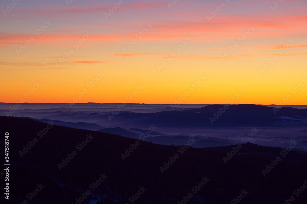 Beautiful golden sky after sunset seen from Sereak mountain in Czech Republic