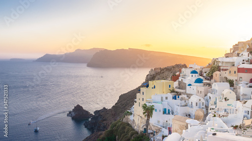 Sunset view of Oia with blue domes, Thirasia in the back, Santorini island, Cyclades, Greece