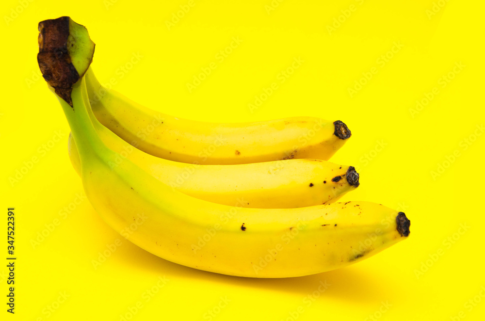 Three bananas side view on a yellow background. The bananas are beaten, scratched, rotten. Yellow bananas with traces of transportation, bruising, damage Three bananas side view on a yellow background. The bananas are beaten, scratched, rotten. Yellow bananas with traces of transportation, bruising, damage