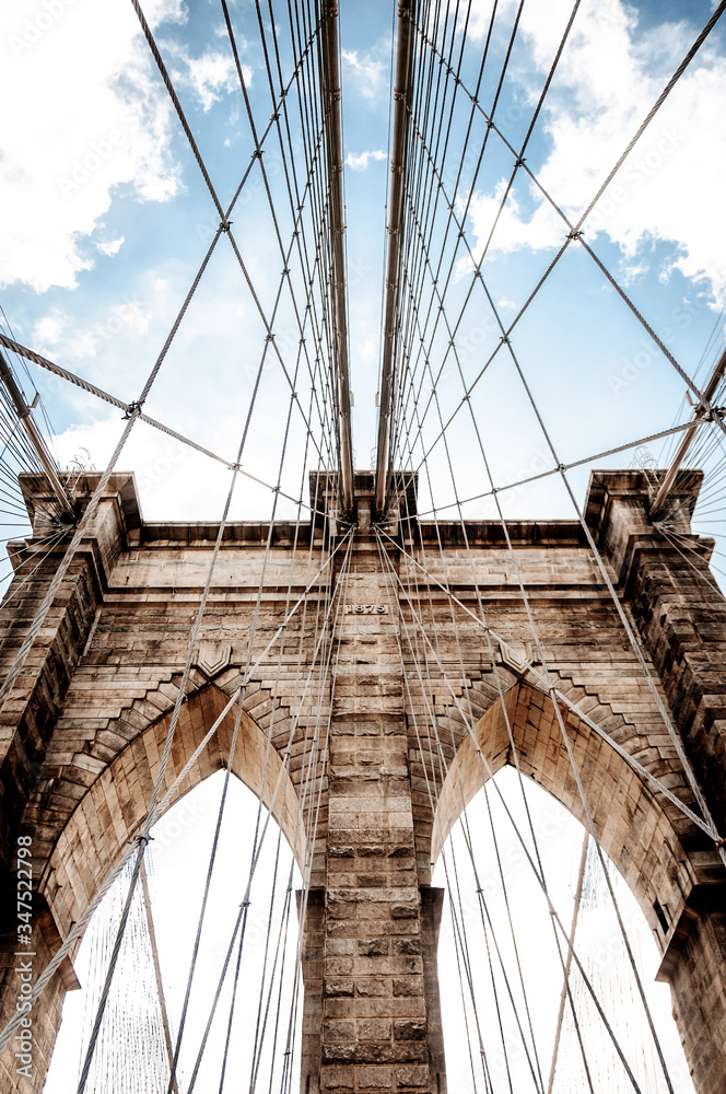Fototapeta premium detail of brooklin bridge arch on a sunny day with blue sky and clouds