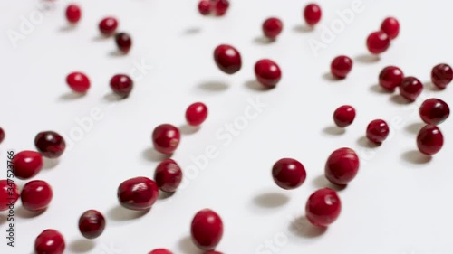 Fresh cranberries rolling on a white board. 