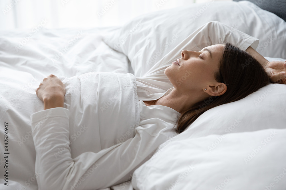 Close up view serene 30s woman sleeping covered with soft warm duvet lying on back in comfortable mattress bed enjoy soft fresh bedclothes, enough rest for body photo in early morning time to wake up Close up view serene 30s woman sleeping covered with soft warm duvet lying on back in comfortable mattress bed enjoy soft fresh bedclothes, enough rest for body photo in early morning time to wake up