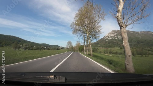 Dashboard point of view POV, driving on Slovenia highway. Dashcam view of asphalt road with beautiful landscape and mountain Nanos in distance. Wide shot, forward dolly moving photo