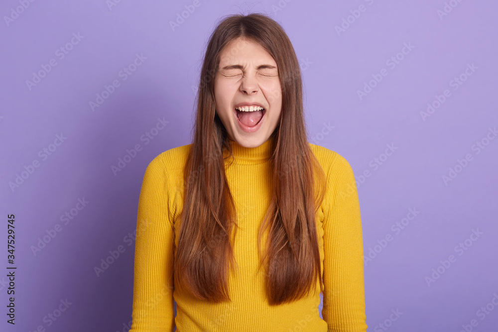 Horizontal shot of woman with long hair, keeping eyes closed, yelling something happily, wearing casual attire, having positive emotions, expressing happiness, lady has great news. People emotions. Horizontal shot of woman with long hair, keeping eyes closed, yelling something happily, wearing casual attire, having positive emotions, expressing happiness, lady has great news. People emotions.