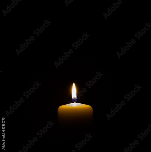 burning candle isolated on black. backgrounds and textures