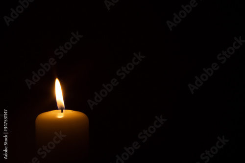 burning candle isolated on black. backgrounds and textures