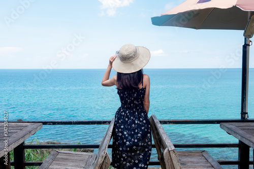 Asian women tourists go to the sea, sit by the sand, beach With beautiful blue sea views Suitable for relaxing on holidays. At Ko Kood, Trat province, Thailand. © Small fish