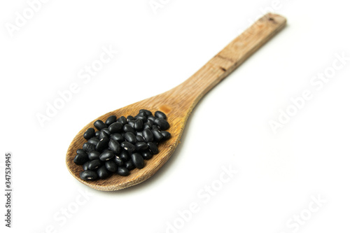 Pile of raw Brazilian Black Beans in a wooden spoon