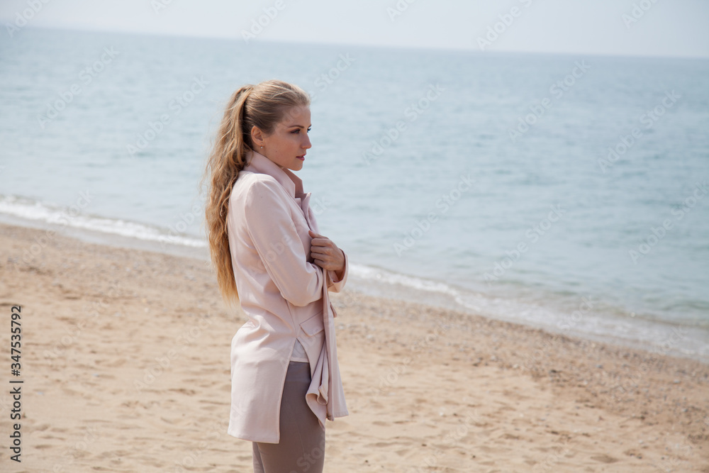 Beautiful blonde woman walks alone on the beach Beautiful blonde woman walks alone on the beach