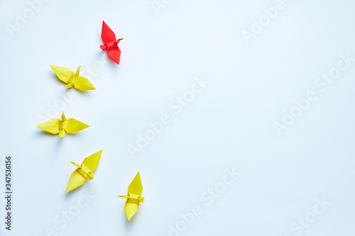 Red origami crane leading group, shallow depth of field