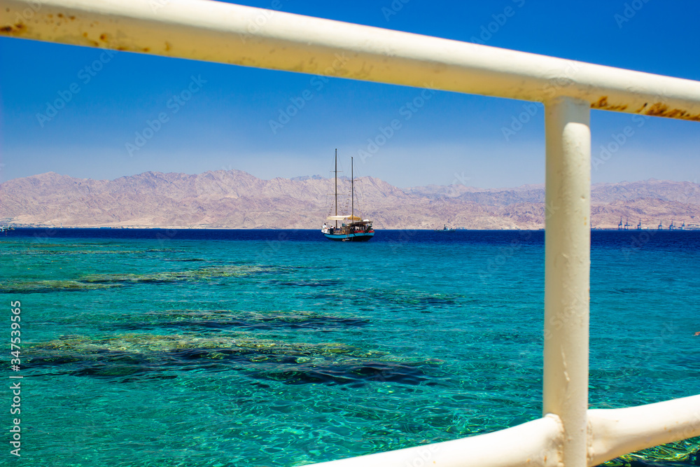 cruise ship summer vacation time Re sea water Gulf of Aqaba Middle East region landscape scenic view with rustic metal fence white frame foreground space