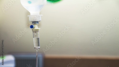 Cinemagraph of a fluid intravenous saline drip in a hospital room. Close up on Set IV fluid intravenous drop saline on a white background. Loop, selective focus, and copy space.