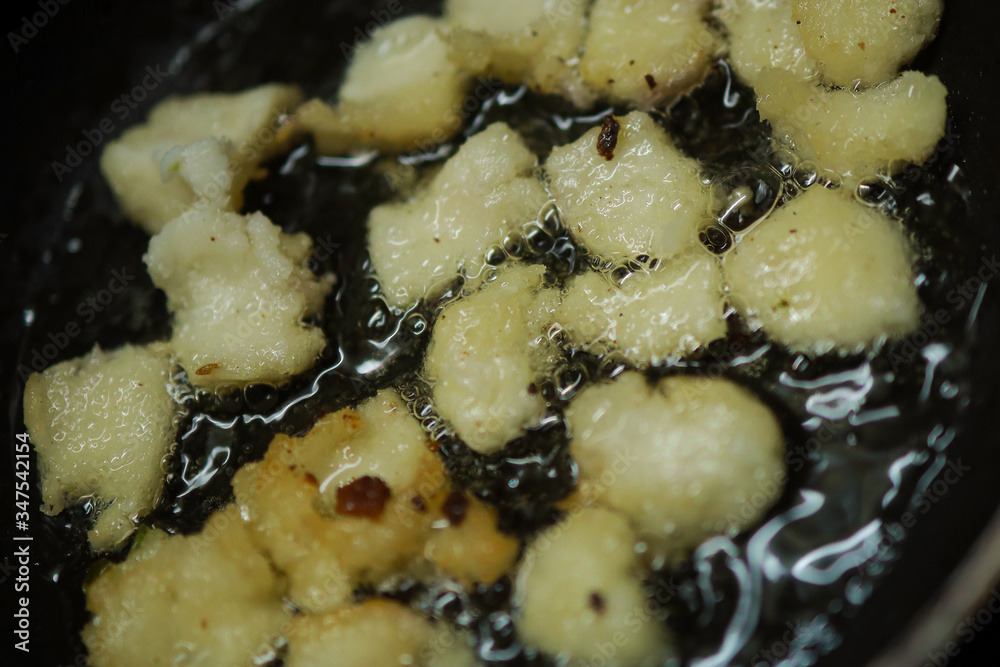 Onion vada with hot oil boiling in cooking pan closeup view, Indian dish making in a traditional home method , some area this is called ulli vada. Onion vada with hot oil boiling in cooking pan closeup view, Indian dish making in a traditional home method , some area this is called ulli vada.