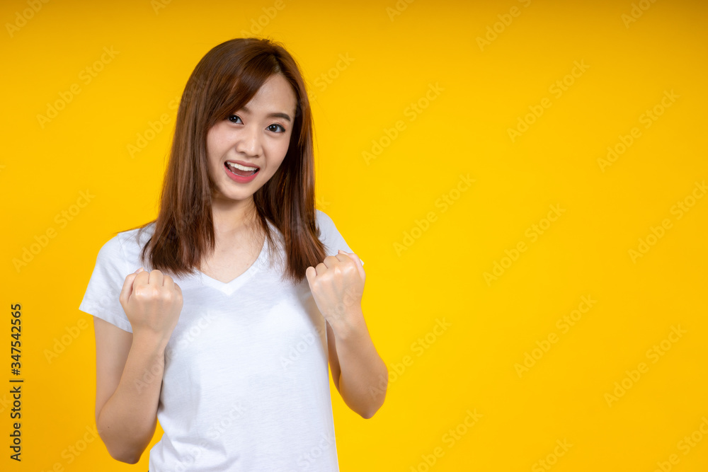 Young elegant Asian woman smiling and expressing a very happy isolated on yellow background Young elegant Asian woman smiling and expressing a very happy isolated on yellow background