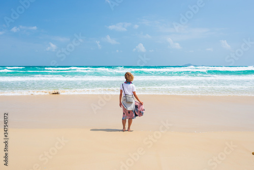 Woman alone on desert beach. Quy Hoa Quy Nhon Vietnam travel destination, central coast between Da Nang and Nha Trang. Gorgeous golden sand bay waving ocean coast line