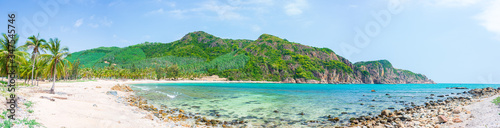 Secluded tropical beach turquoise transparent water palm trees, Bai Om undeveloped bay Quy Nhon Vietnam central coast travel destination, desert white sand beach no people clear blue sky, expansive