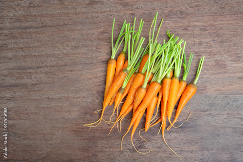 Fresh carrots bunch on wooden background.