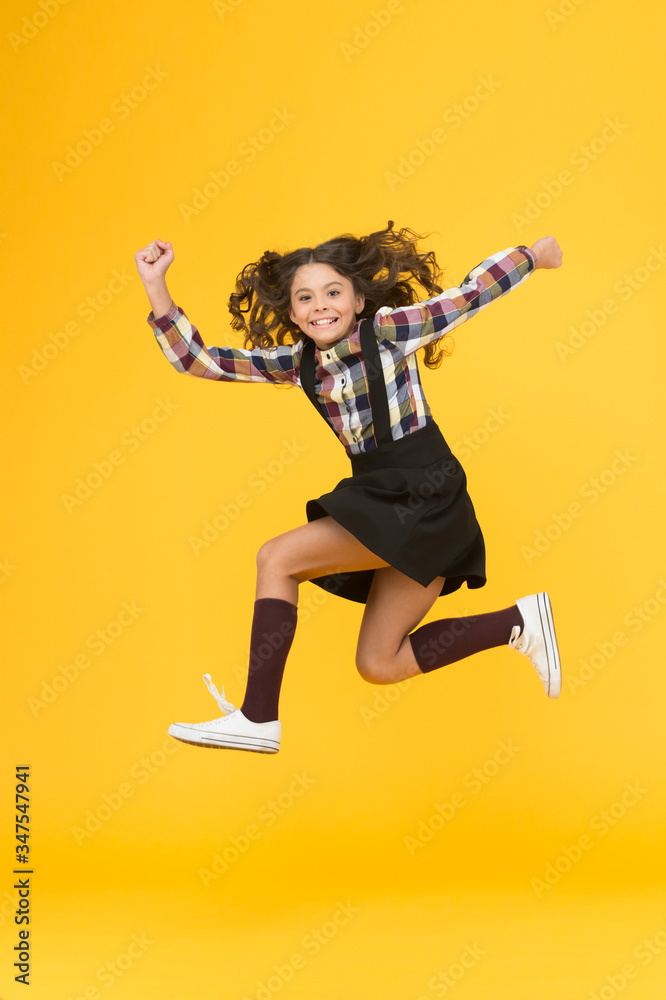 Energy and ambition. Energetic girl run to school. Happy child in midair yellow background. Childhood energy. Maintaining kinetic energy. School fashion. Youth and energy Energy and ambition. Energetic girl run to school. Happy child in midair yellow background. Childhood energy. Maintaining kinetic energy. School fashion. Youth and energy